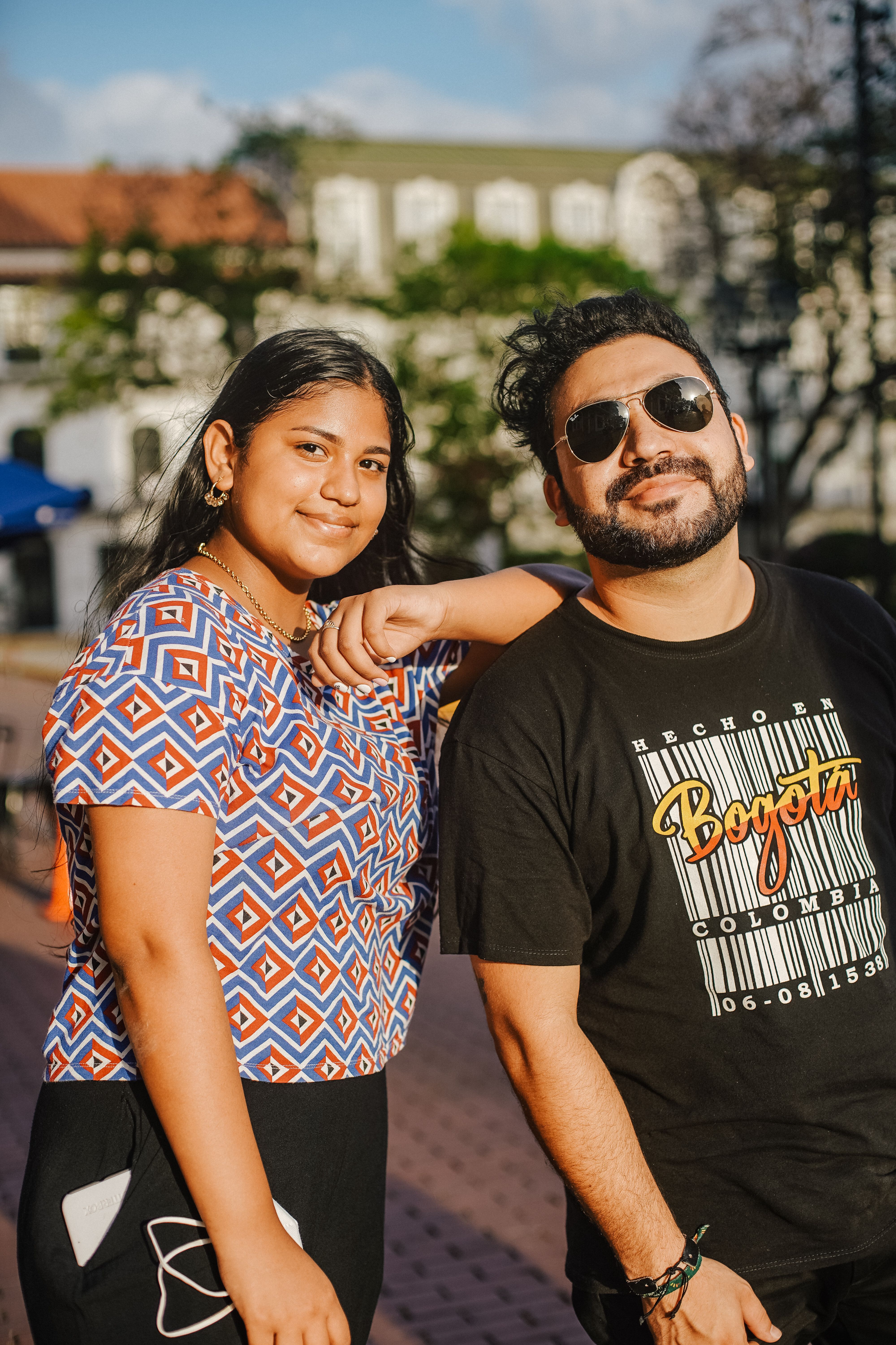 Smiling young adults enjoying a sunny day in an urban setting.