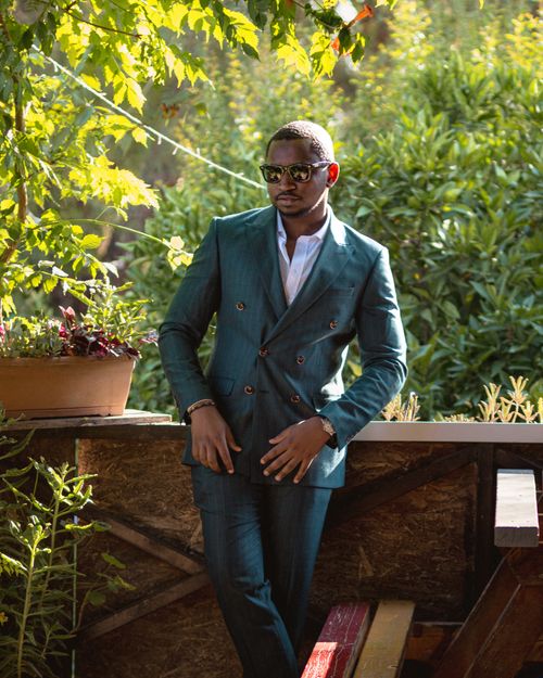 Free Elegant man in a suit standing outdoors with sunglasses in Abuja, Nigeria. Stock Photo