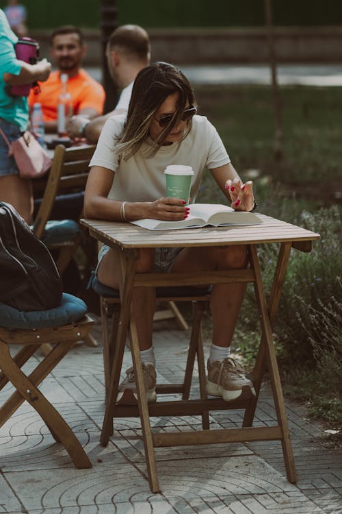 A nice girl reading a book and drinking coffee