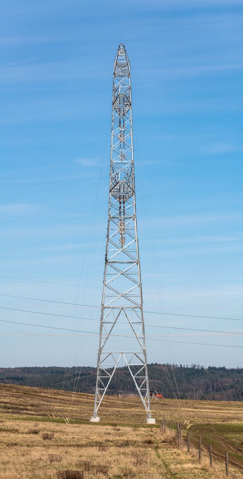 A Tall Electricity Tower on a Field 