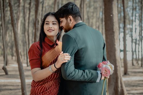 Free A loving couple dressed for a wedding poses in a serene forest setting, highlighting romance and nature. Stock Photo