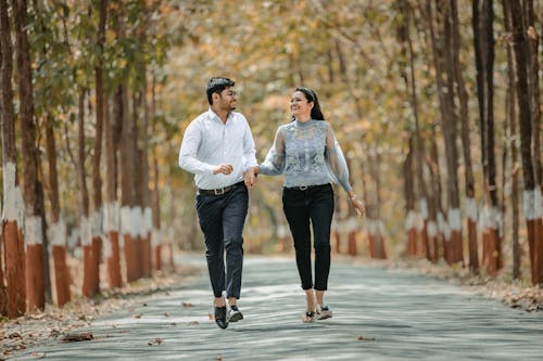 Young Happy Couple Walking on a Road in a Park