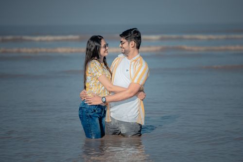 Free Young couple standing and embracing in shallow sea waters on a sunny day, enjoying their time together. Stock Photo