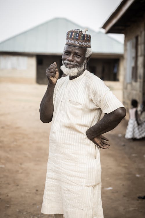 Man Wearing Kufi Hat in African Village