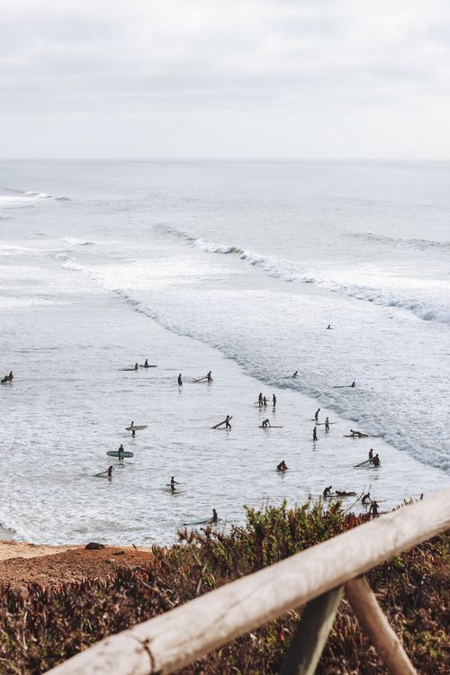 Free A vibrant scene of surfers riding waves on a cloudy day, capturing the essence of seaside adventure. Stock Photo