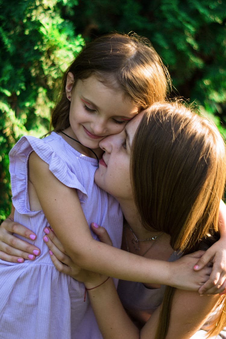 Mother And Daughter Standing Outside And Hugging 