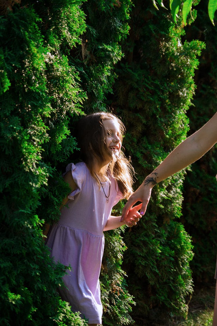 Woman Reaching Her Hand Toward A Little Girl 