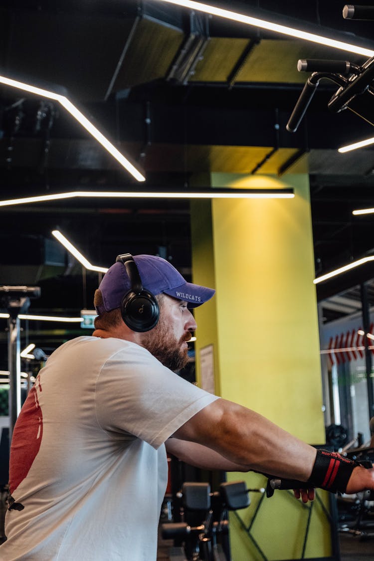 Man Wearing Headphones And A Baseball Cap At The Gym 