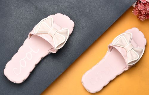 Free Elegant pink slippers with bows on textured background, perfect for fashion and lifestyle themes. Stock Photo