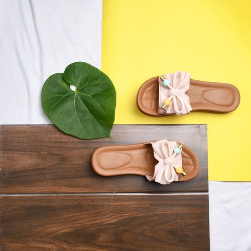 Free Stylish pink leather sandals on wooden surface with a green leaf accent and vibrant background. Stock Photo