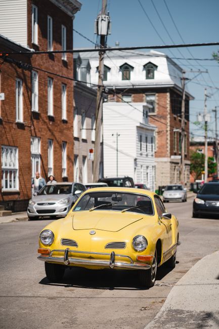 Classic yellow Volkswagen car on a busy street in Québec, Canada.