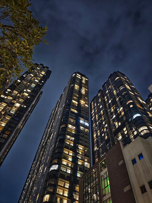 Illuminated Skyscrapers Against a Cloudy Evening Sky