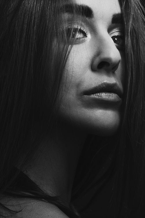 Free Intense black and white close-up portrait of a woman with striking features. Stock Photo