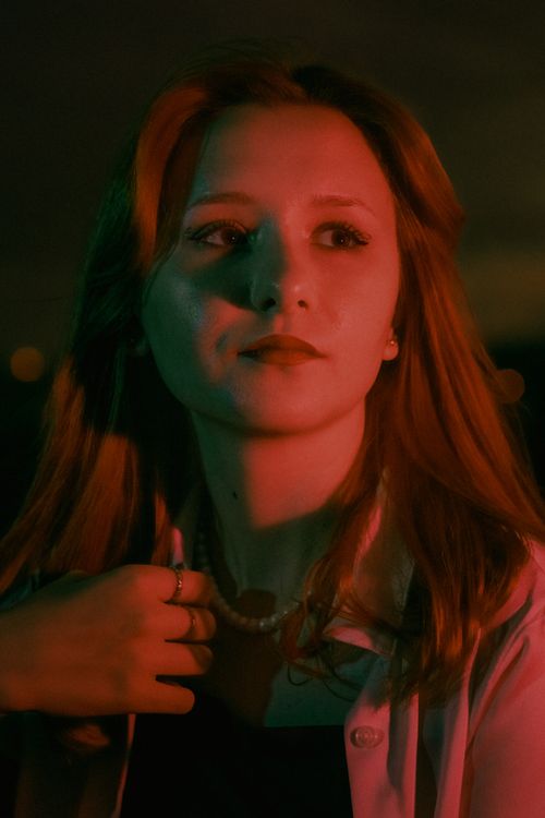 Free Artistic portrait of a young woman illuminated by red and green light, showcasing a dramatic mood. Stock Photo