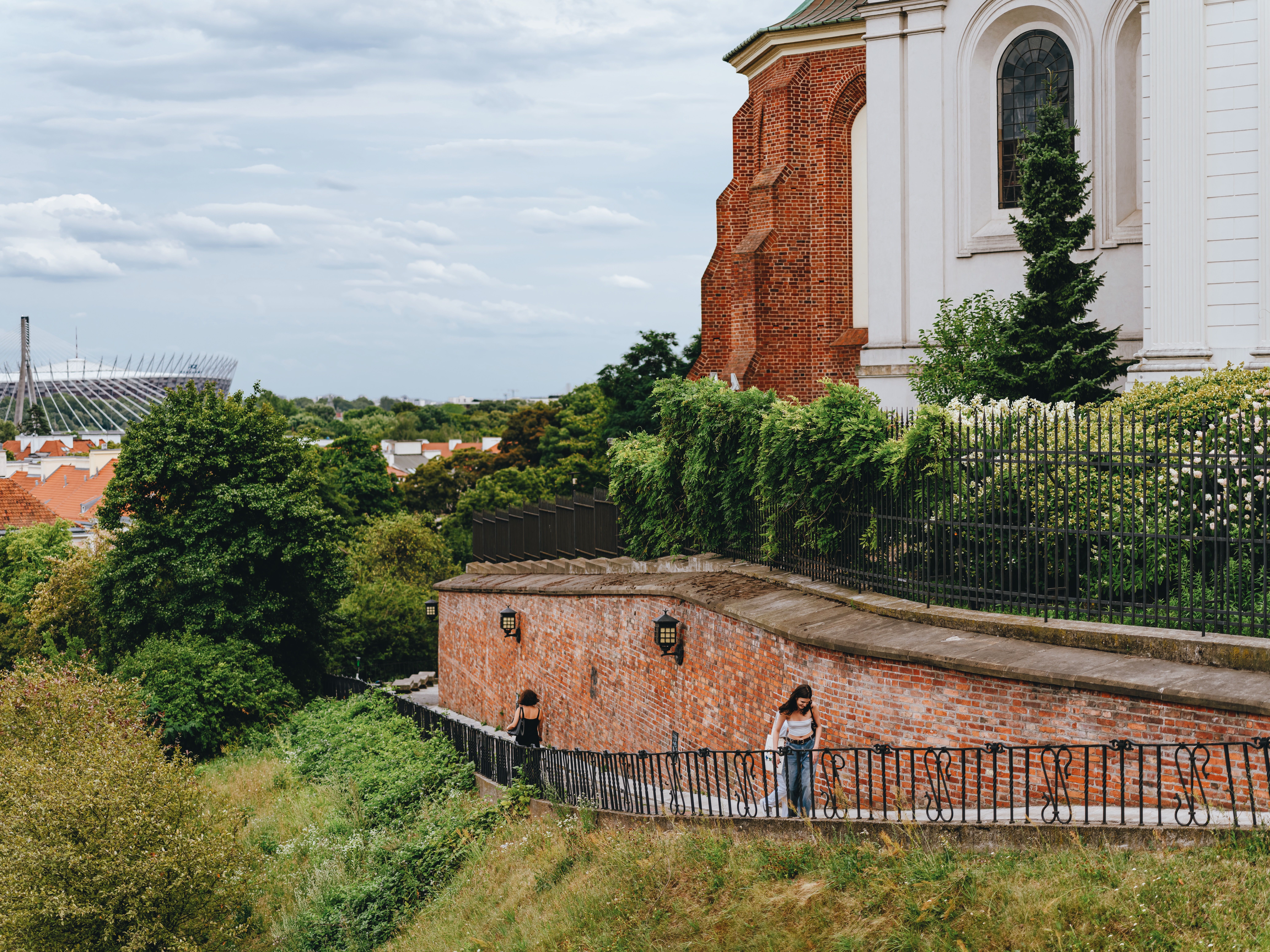 View of Warsaw's historic fortifications with National Stadium in the background during summer.