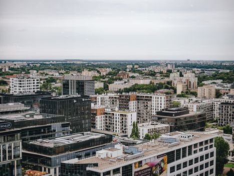 Aerial view of Warsaw skyline featuring modern and residential buildings under cloudy sky.