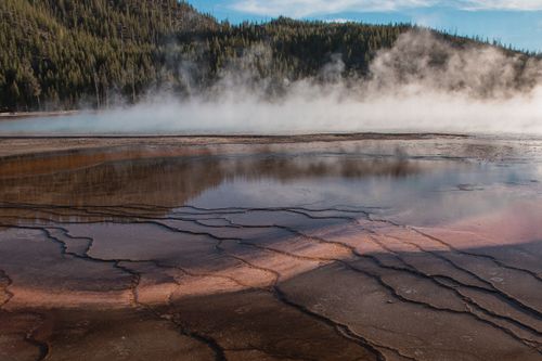 Free A mesmerizing view of a geothermal area with colorful mineral deposits and rising steam. Stock Photo