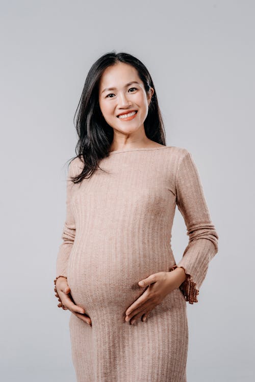 Smiling Pregnant Woman in in Maternity Dress