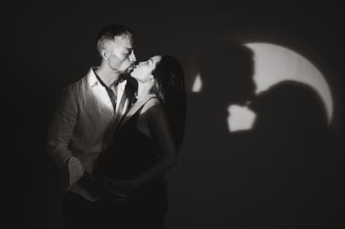 Black and White Studio Portrait of a Pregnant Woman and a Man Kissing
