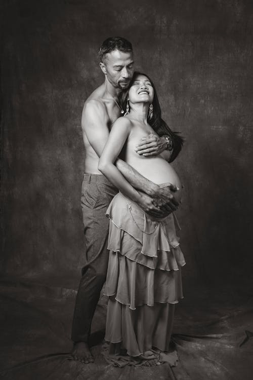 Photo of a Man Embracing his Pregnant Partner 