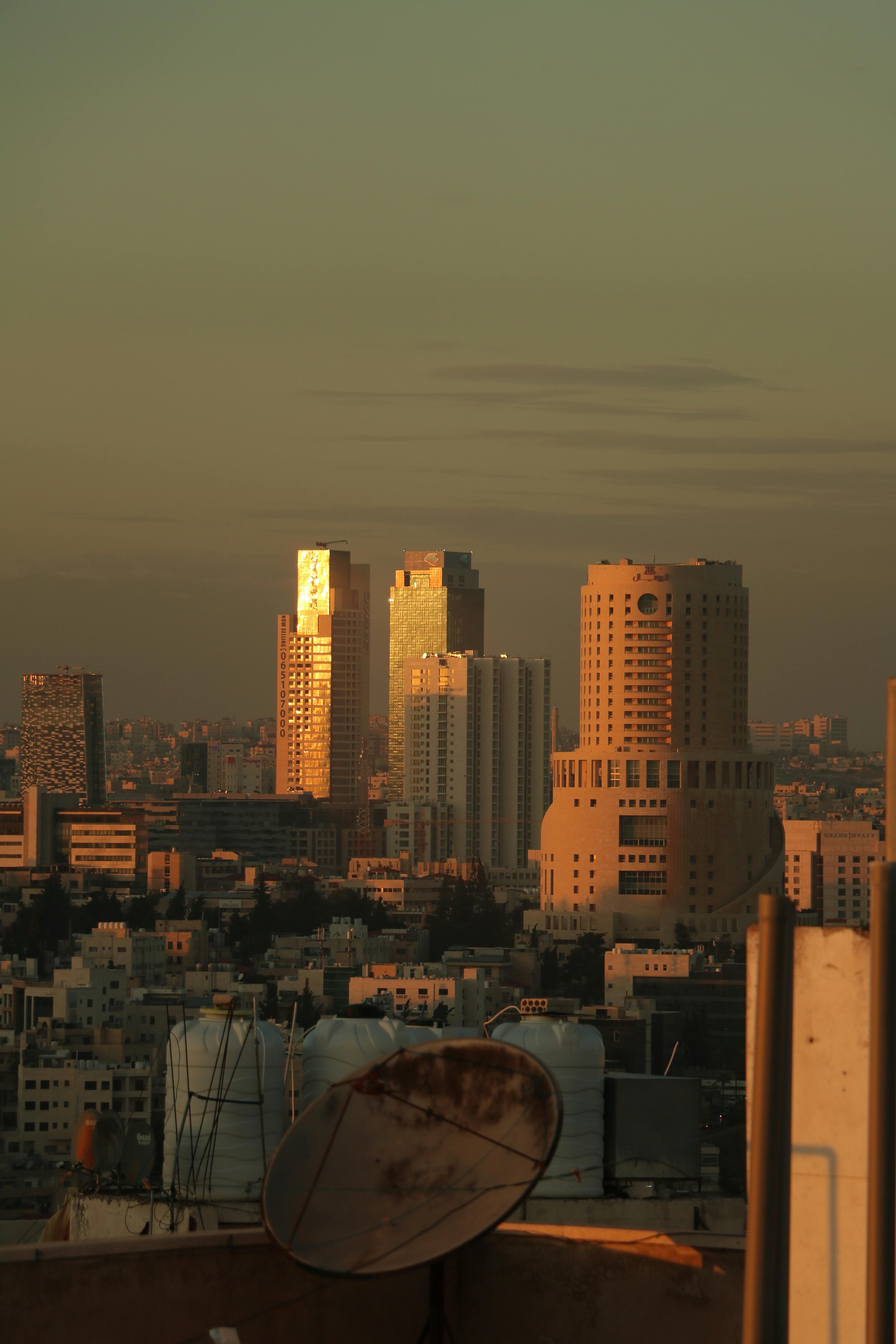 Golden hour city skyline with modern skyscrapers and urban structures captured during twilight.