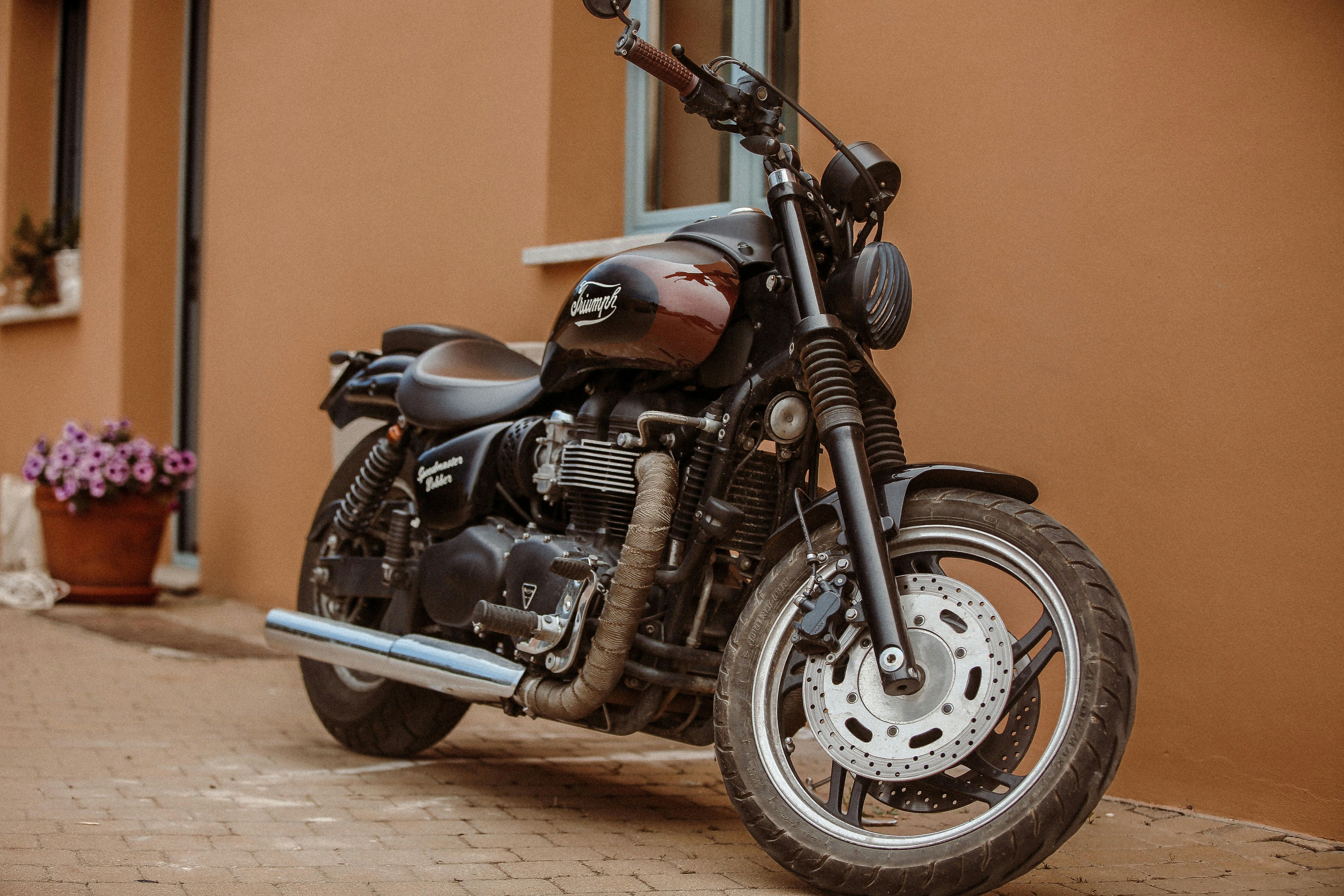 A stylish Triumph motorcycle parked in front of a building in an urban environment.