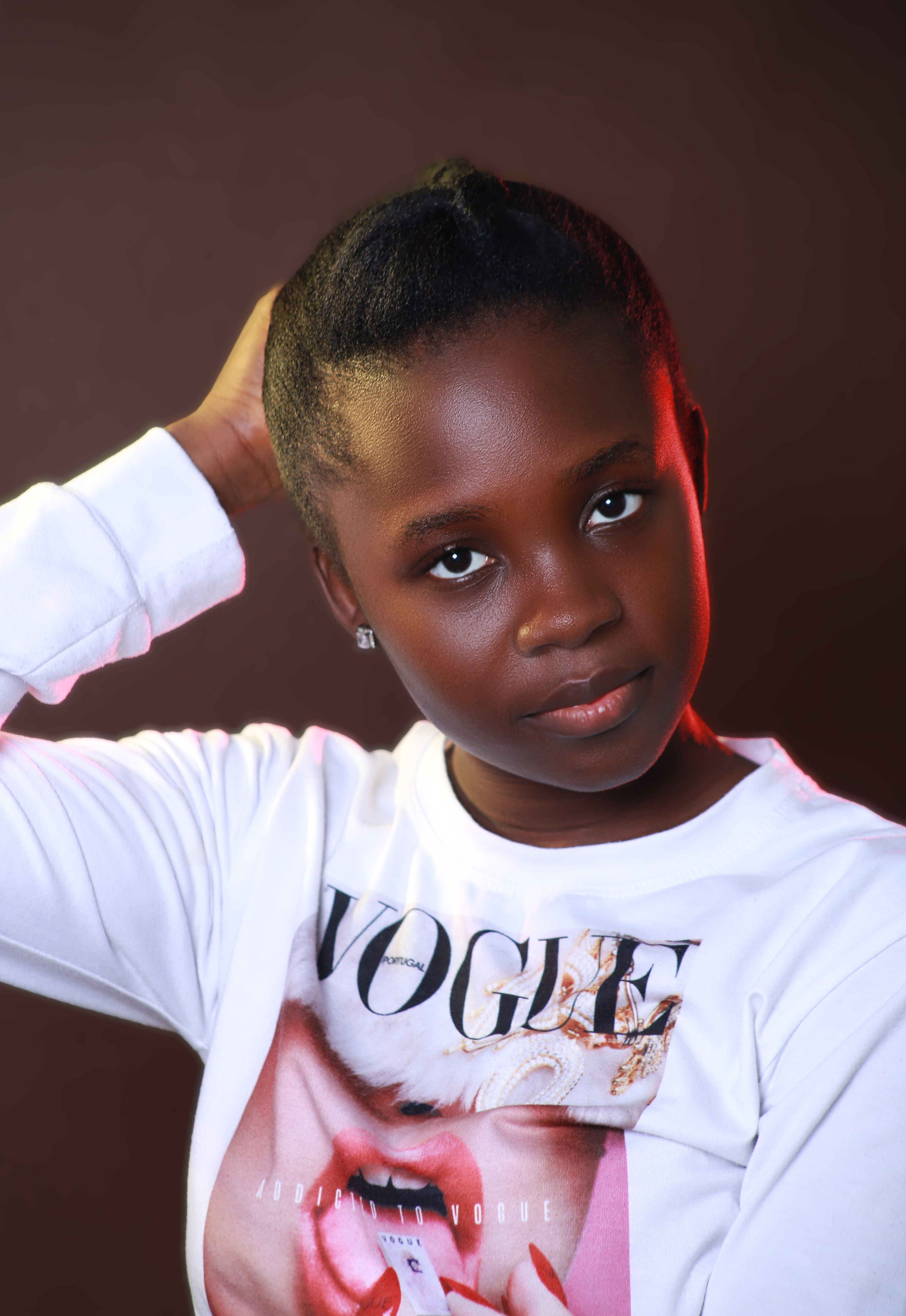 Elegant studio portrait of a young woman wearing a Vogue t-shirt.