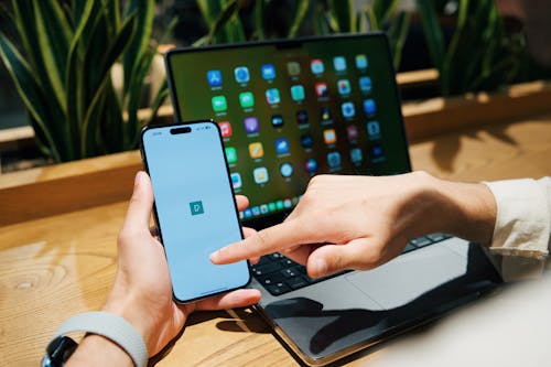 Man Working on Phone and Laptop