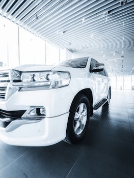 White SUV displayed in a contemporary dealership with modern architecture, highlighting sleek automotive design.