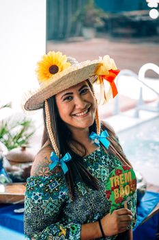 Cheerful woman wearing a festive straw hat at a summer gathering.