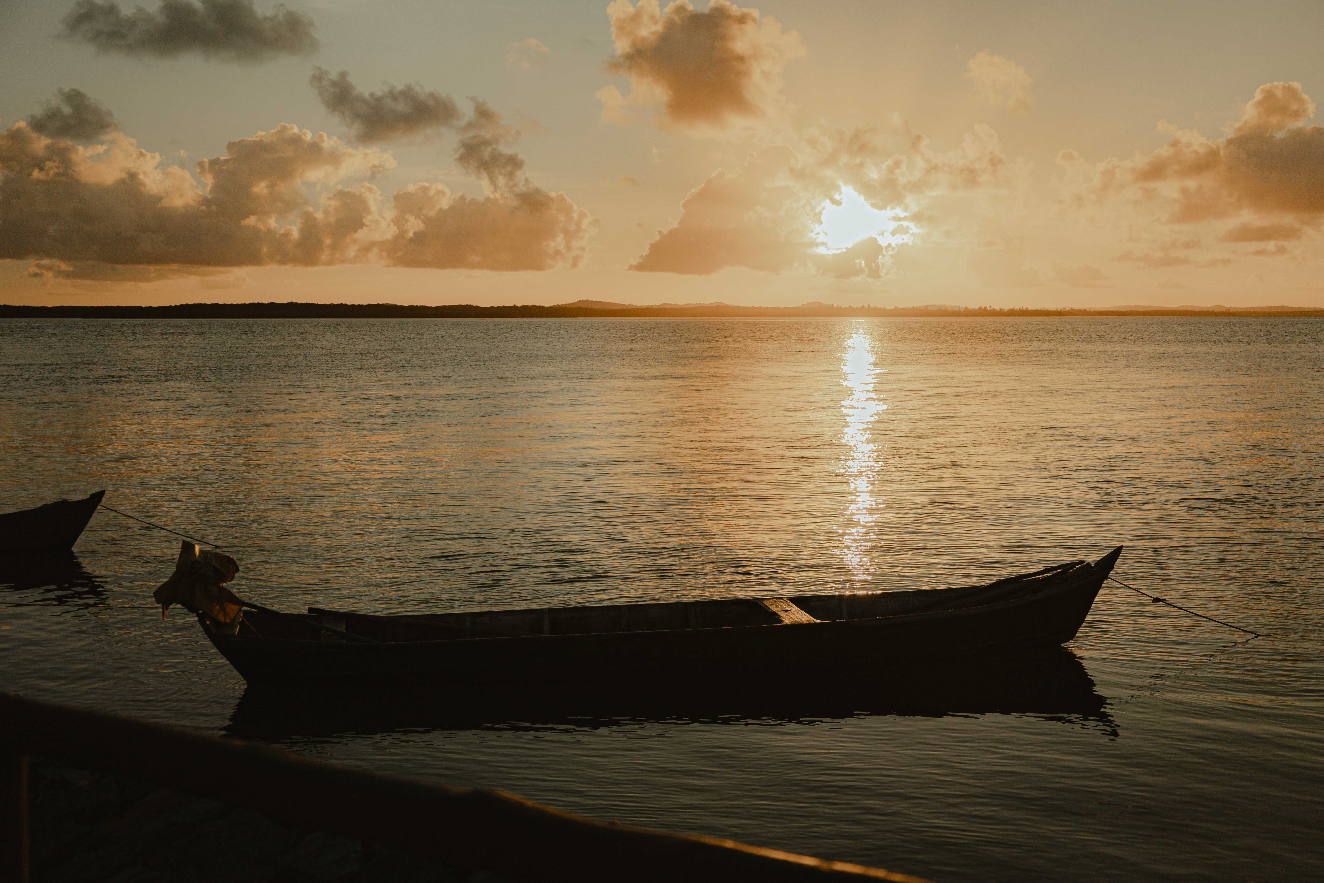 Silhouetted Boat on the Shore at Sunset · Free Stock Photo
