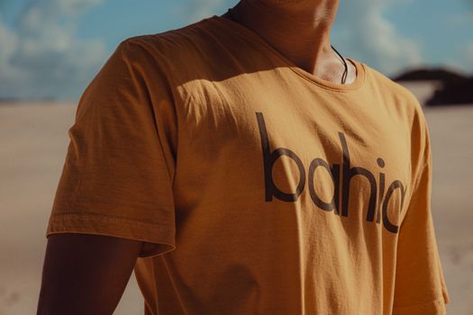 Close-up of a man in a stylish t-shirt enjoying the sunny outdoors.