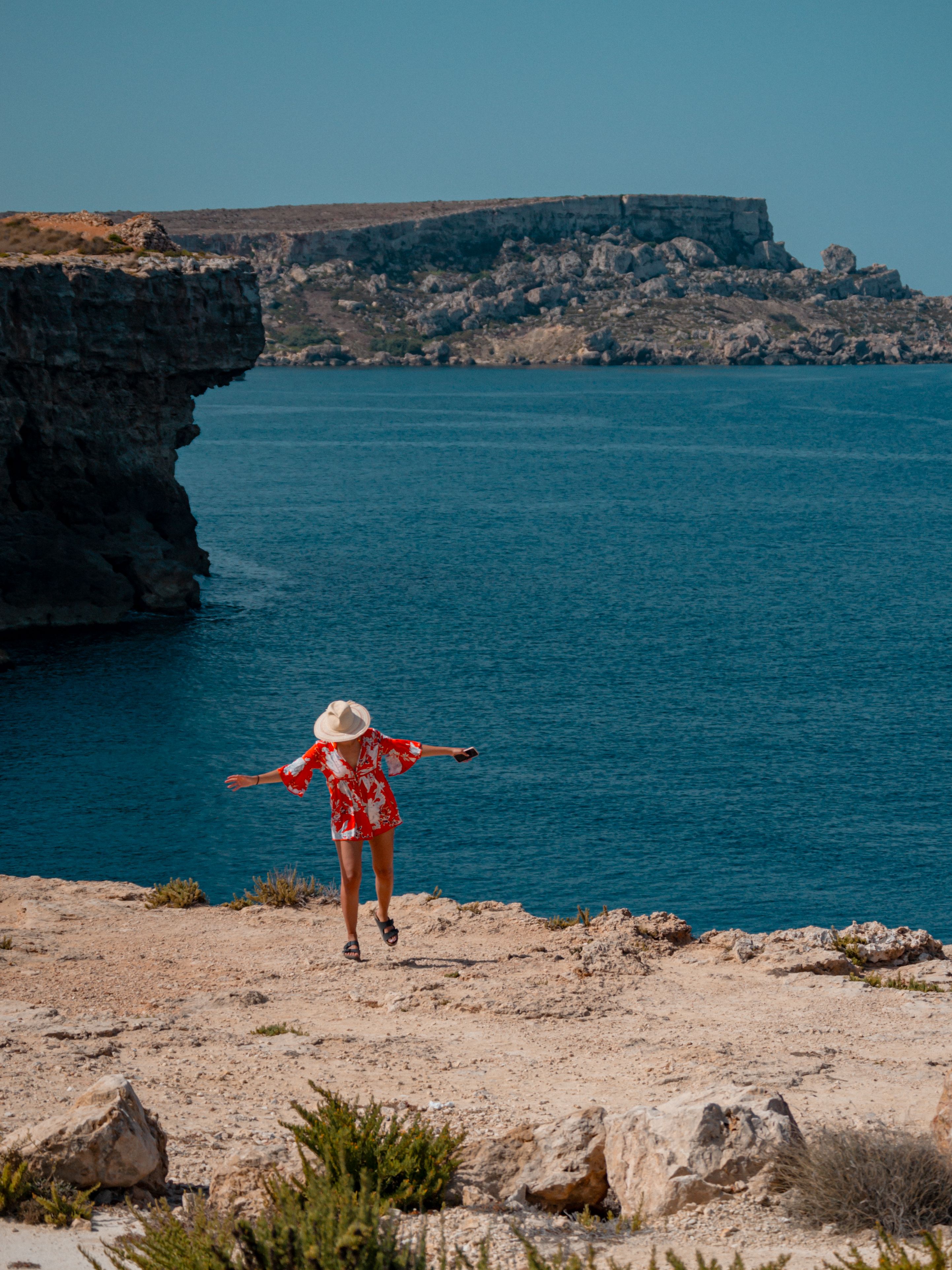 Woman in Hat on Cliff on Sea Shore · Free Stock Photo