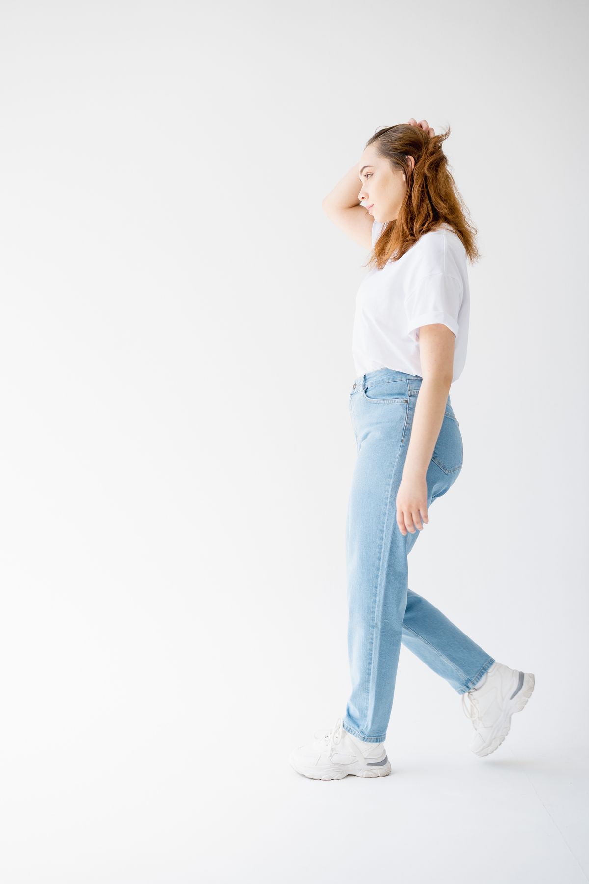 Woman styled in straight-leg jeans with a t-shirt and sneakers