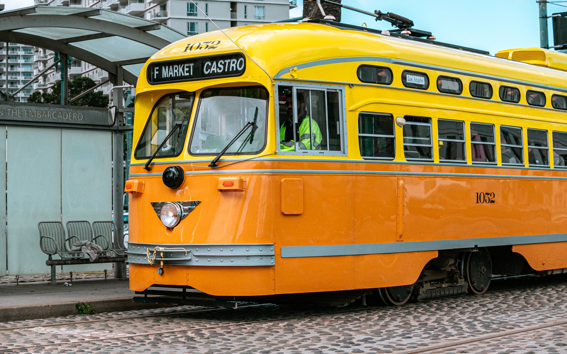 Orange vintage streetcar on F Market & Castro line in San Francisco, capturing urban transportation.
