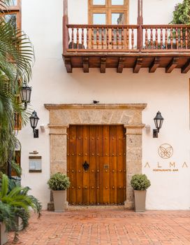 Rustic wooden doors and charming balcony of ALMA Restaurante-Bar with classic architecture.