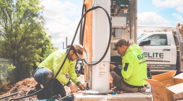 Electricians wiring a control box during a safety check
