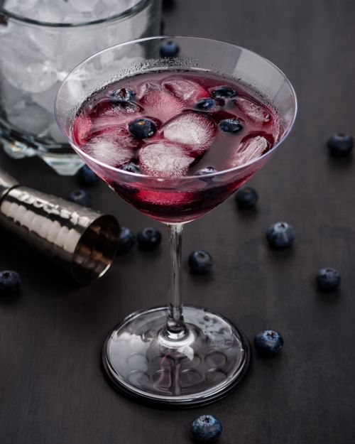 Free A close-up shot of a blueberry cocktail with ice cubes in a martini glass. Stock Photo