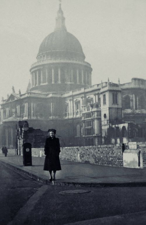 Free A black and white vintage photo of St Paul's Cathedral in foggy London with a woman standing in the foreground. Stock Photo