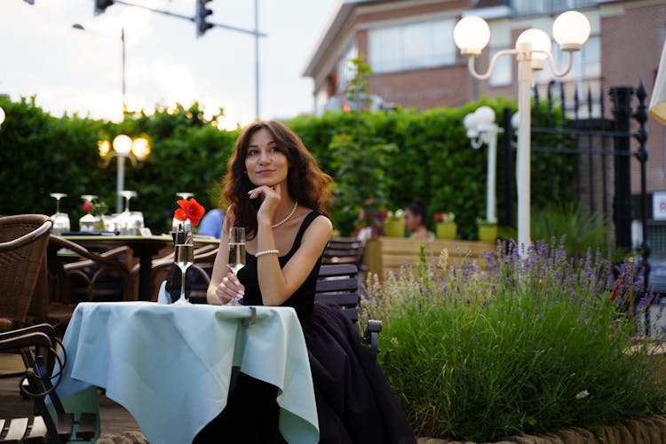 Woman Drinking Wine At An Outdoor Restaurant Table 