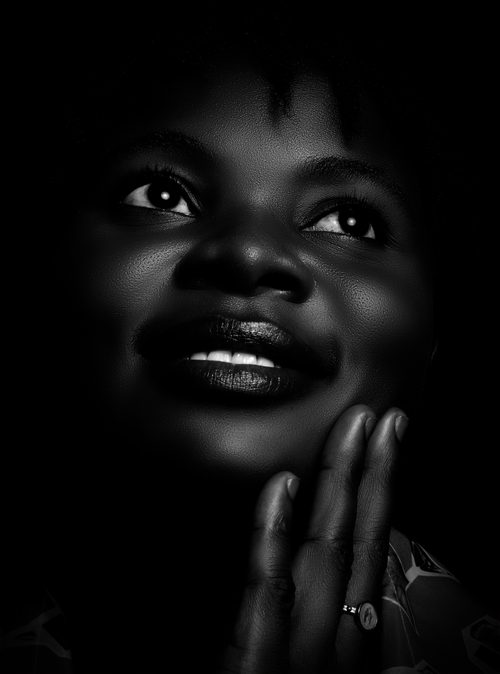 Free Close-up black and white portrait of a smiling woman looking up thoughtfully. Stock Photo