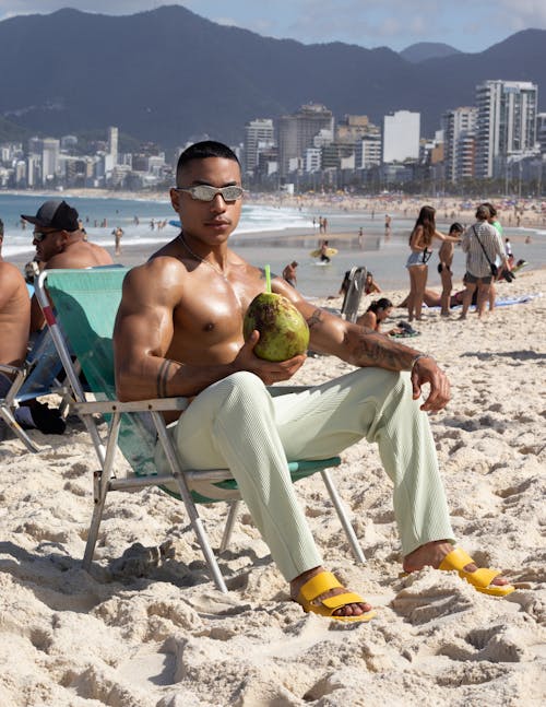 Free Muscular Man at Beach with Coconut Drink Stock Photo