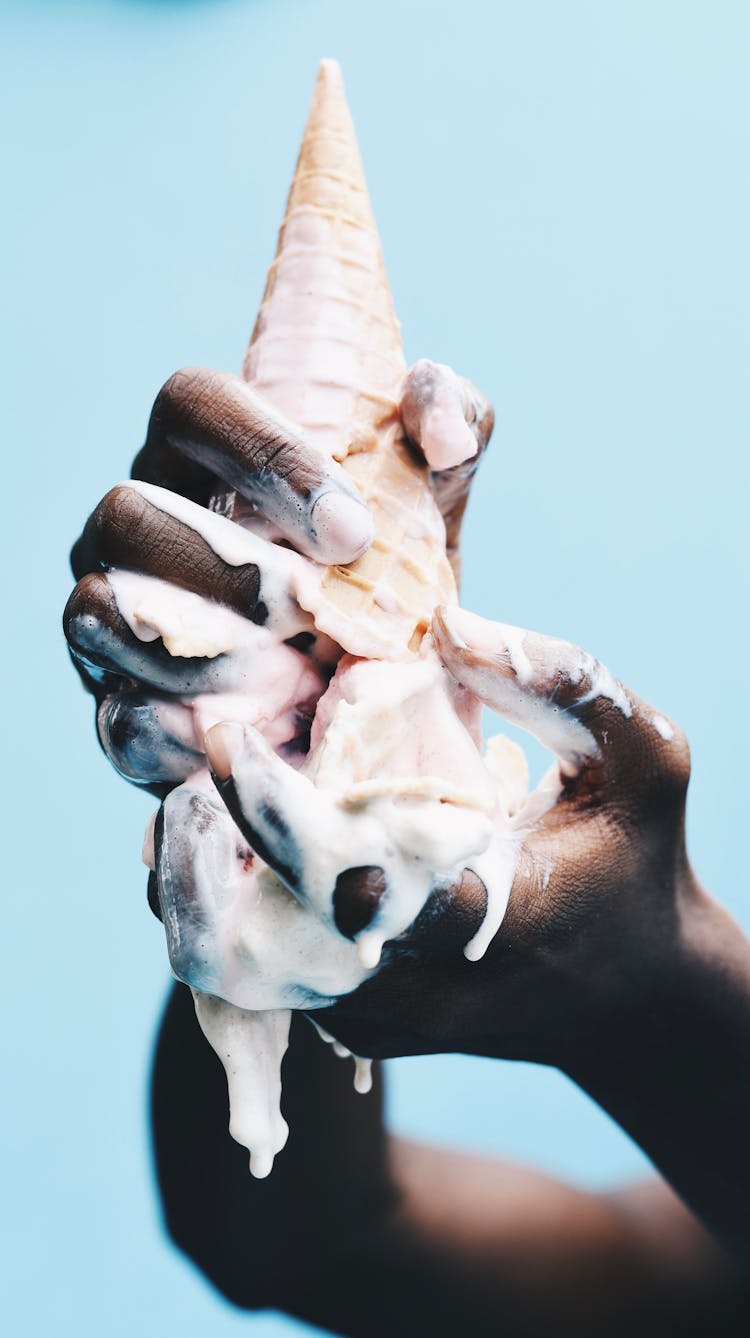 Man Holding A Melting Ice Cream Cone Upside Down 