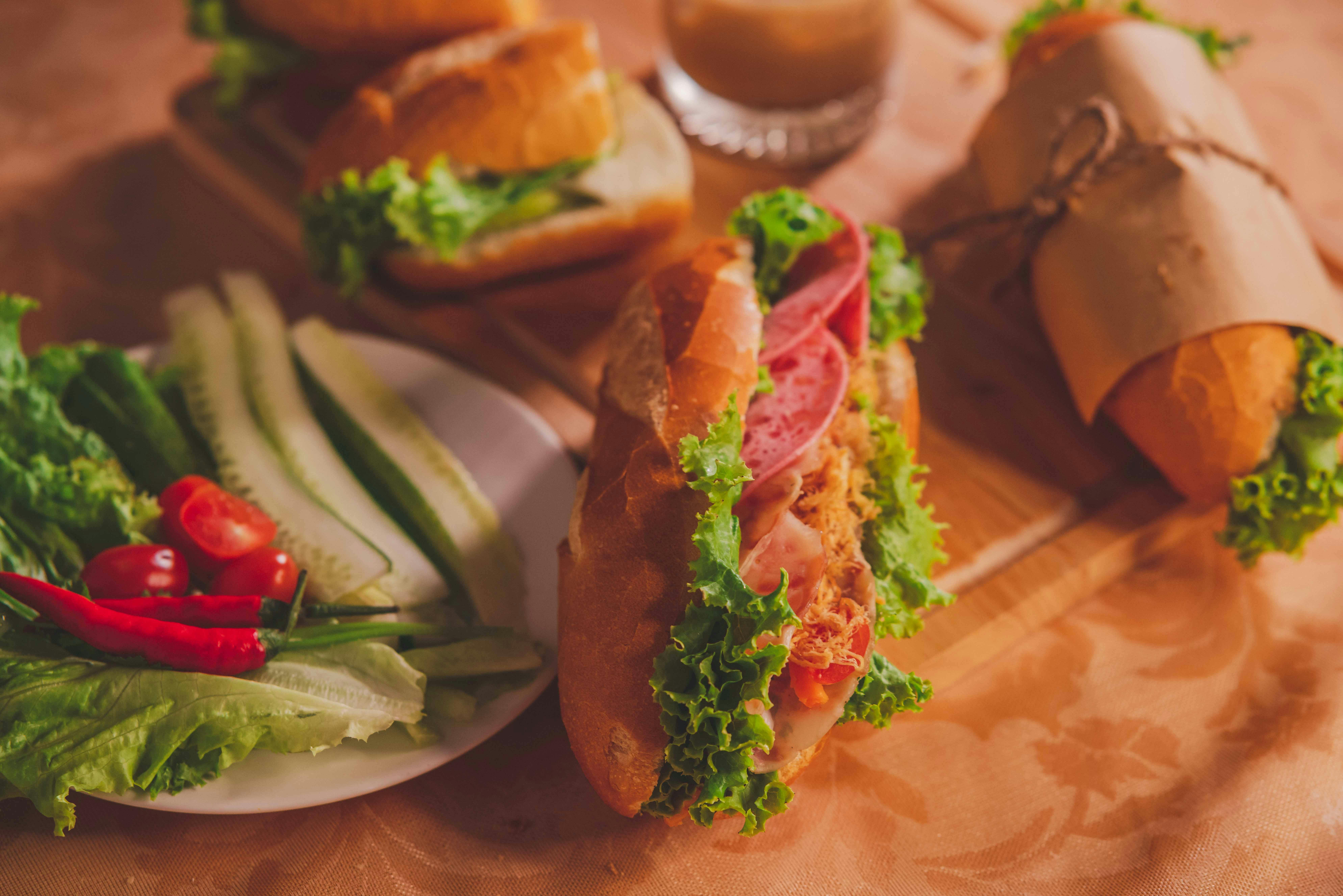 Close-up of delicious Vietnamese Banh Mi sandwiches with fresh vegetables on a table.