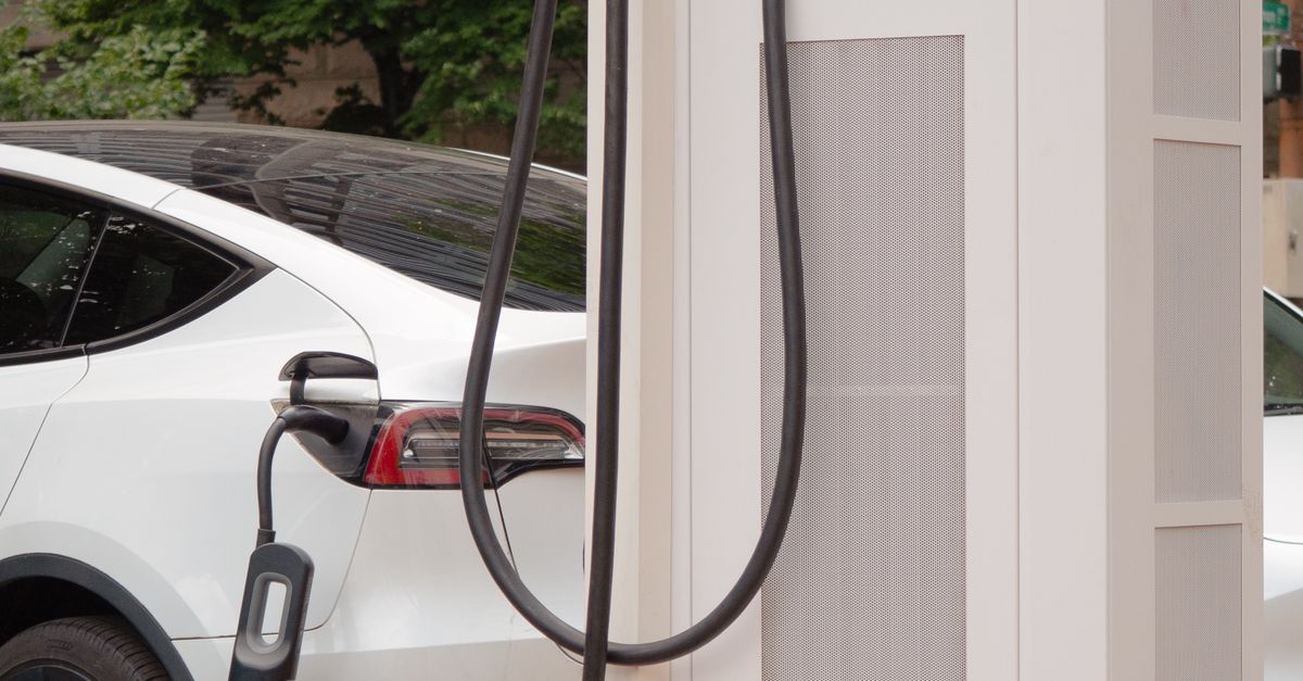 White electric car connected to a city charging station