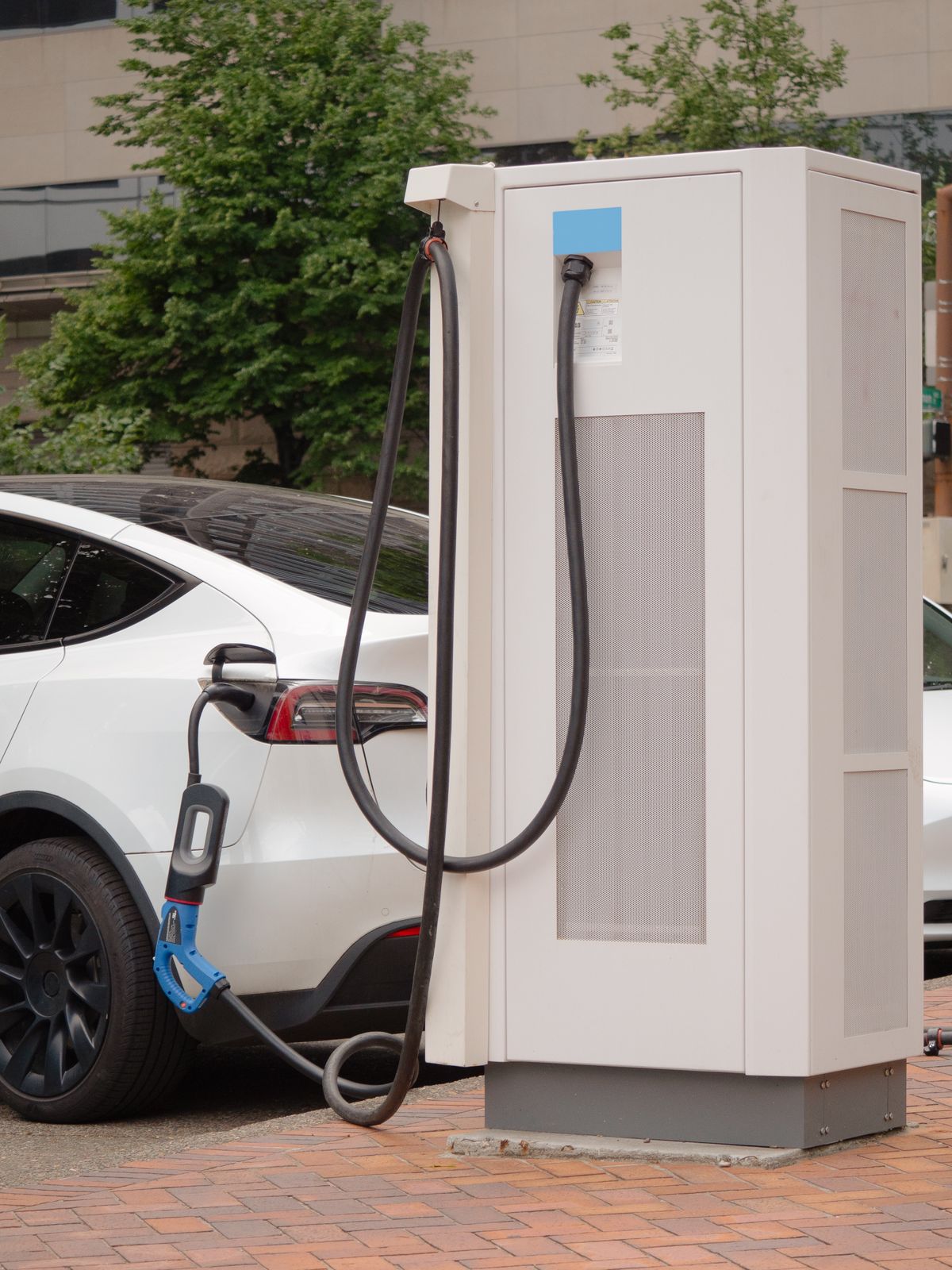 White electric car plugged into a charger