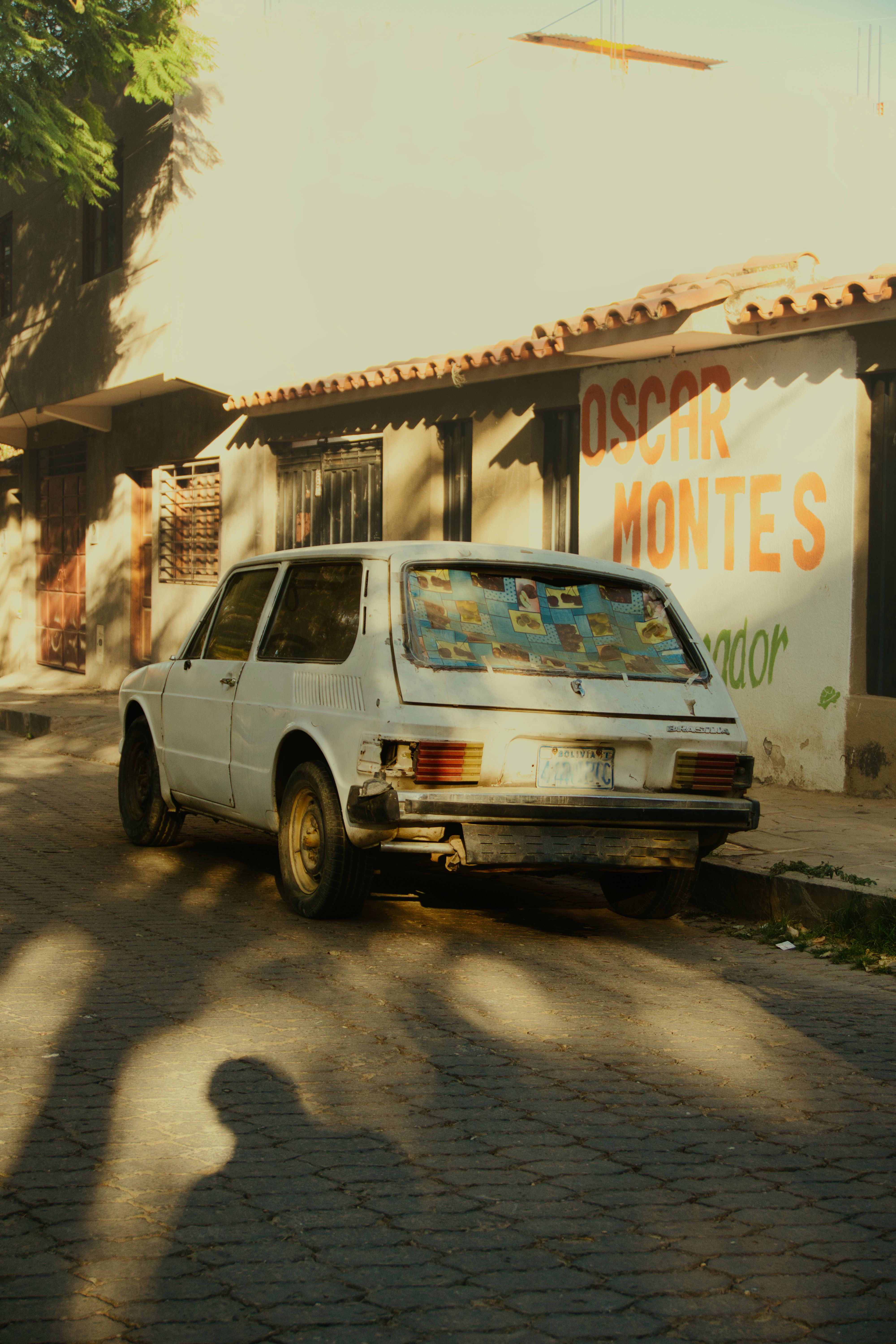 Rustic vintage car parked on a sunlit street in Tarija, Bolivia. Urban retro vibes.