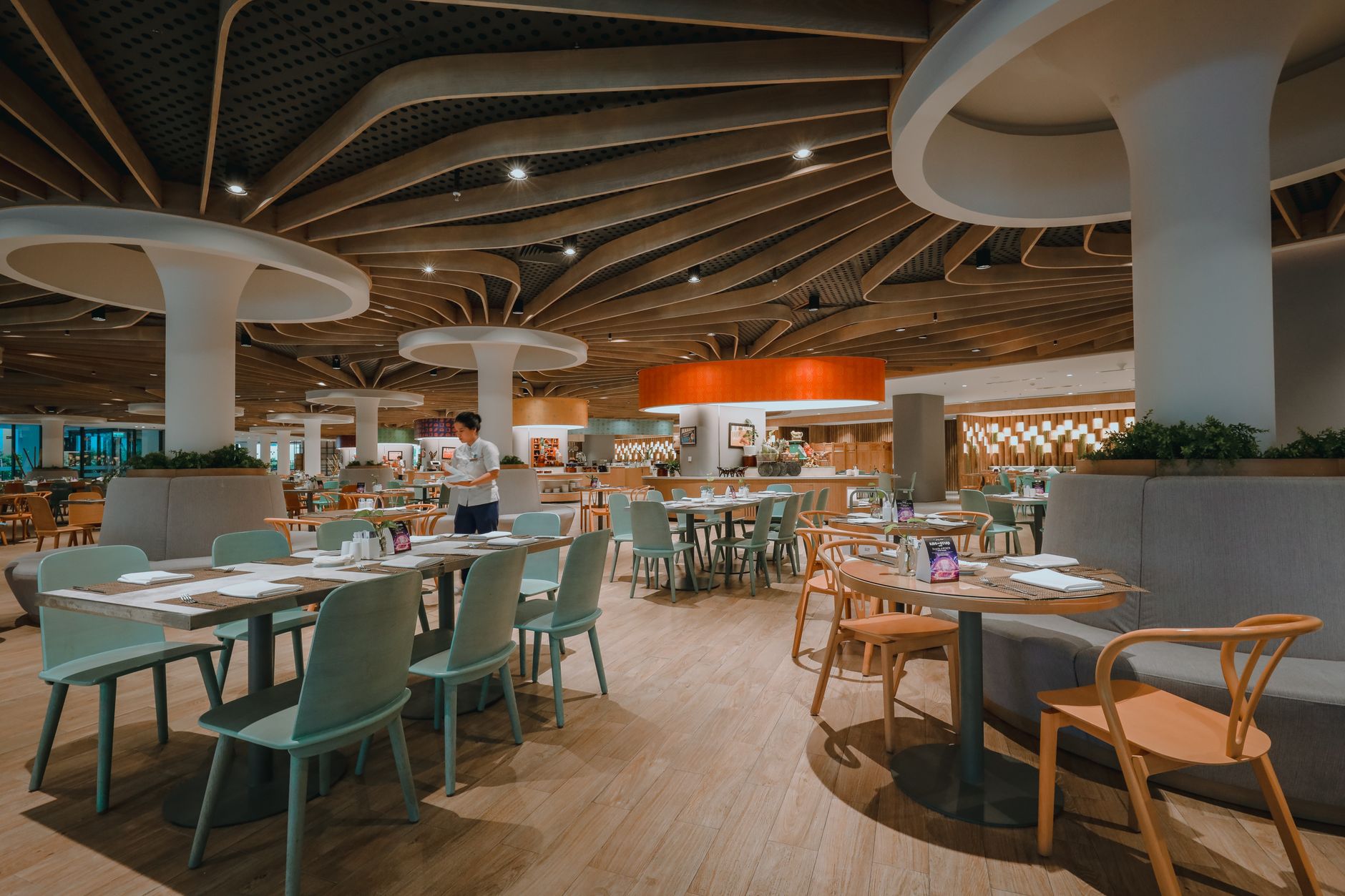 Contemporary restaurant interior showcasing elegant furniture and unique ceiling design.