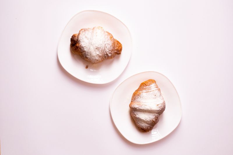 Flat white and butter croissant prepared for breakfast
