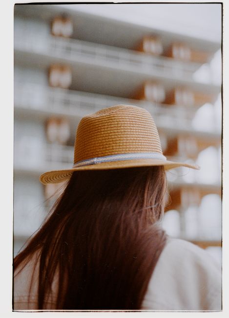 Stylish woman in a sun hat enjoys the summer vibes in Antwerp, Belgium.